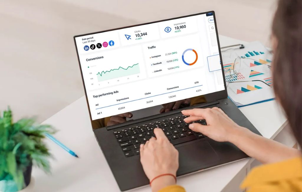 A digital marketer analyzing a social media performance dashboard on a laptop, showing graphs for engagement and conversions